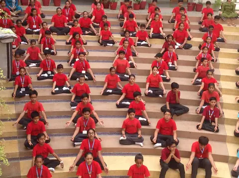Anand Niketan students practising yoga on the amphitheatre steps